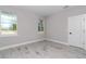 Bedroom features neutral paint colors, updated flooring, a door, and two windows at 9095 Sw 125Th Ter, Dunnellon, FL 34432