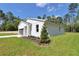 A well-kept home with a white exterior, complemented by a lush lawn and an attached garage at 9095 Sw 125Th Ter, Dunnellon, FL 34432