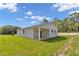 Home's exterior shows a covered patio and a large grassy backyard at 9095 Sw 125Th Ter, Dunnellon, FL 34432