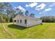 A well-maintained home with a white exterior, situated on a verdant lawn and surrounded by trees at 9095 Sw 125Th Ter, Dunnellon, FL 34432