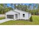 Charming home showcasing a two-car garage, manicured lawn, and beautiful surrounding trees at 9095 Sw 125Th Ter, Dunnellon, FL 34432