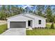 Charming home with a grey garage door, lush lawn, and well-kept landscaping at 9095 Sw 125Th Ter, Dunnellon, FL 34432