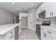 Bright kitchen features white cabinets, stainless steel appliances, and quartz countertops at 9095 Sw 125Th Ter, Dunnellon, FL 34432
