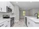 Well-lit kitchen with stainless appliances, and white cabinets and hard surface floors at 9095 Sw 125Th Ter, Dunnellon, FL 34432