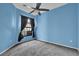Blue bedroom with grey carpet, ceiling fan and window coverings at 140 Stratford Ct, Haines City, FL 33844