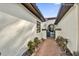 A walkway between two white walls leads to a gated entry at 140 Stratford Ct, Haines City, FL 33844
