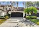 Two-story villa with dark brown garage doors, lush landscaping, and a Spanish-style roof at 140 Stratford Ct, Haines City, FL 33844