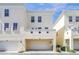 Beige townhome with a two-car garage and landscaping at 1407 Chatfield Pl, Orlando, FL 32814