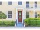 Townhouse entrance with red door, white columns, and landscaping at 1407 Chatfield Pl, Orlando, FL 32814