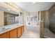 Main bathroom with double vanity, soaking tub, and walk-in shower at 14236 Golden Rain Tree Blvd, Orlando, FL 32828