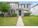 Two-story house with gray siding, black door, and landscaped lawn at 14236 Golden Rain Tree Blvd, Orlando, FL 32828