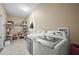 Laundry room with washer, dryer, and storage shelves at 14236 Golden Rain Tree Blvd, Orlando, FL 32828