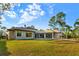 Sprawling backyard showcasing a modern home with a well-manicured lawn and lush landscaping under a bright blue sky at 16902 Vinci Way, Montverde, FL 34756