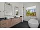 A modern bathroom features dual sinks, a freestanding tub, elegant fixtures, and a herringbone tile floor at 16902 Vinci Way, Montverde, FL 34756