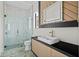 Modern bathroom with glass walk-in shower, decorative tile floors and a geometric mirror at 16902 Vinci Way, Montverde, FL 34756