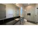 Elegantly appointed bathroom featuring marble-tiled shower, modern vanity with black countertop and dual shower heads at 16902 Vinci Way, Montverde, FL 34756