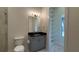 Well-lit bathroom features a vanity with a sleek black countertop, complemented by an open linen closet at 16902 Vinci Way, Montverde, FL 34756