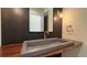 Stylish powder room features a unique concrete sink, wood counter, and modern lighting at 16902 Vinci Way, Montverde, FL 34756