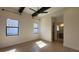 Inviting bedroom featuring hardwood floors, ceiling beams, and an adjacent ensuite bathroom for convenience at 16902 Vinci Way, Montverde, FL 34756
