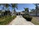 Long driveway leading up to a two-story home with tropical landscaping, a tile roof and dark trim at 16902 Vinci Way, Montverde, FL 34756