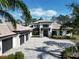 Stunning two-story home with a tile roof, dark trim, a paver driveway and tropical landscaping at 16902 Vinci Way, Montverde, FL 34756