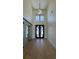 Bright foyer featuring hardwood floors, high ceilings, a modern light fixture, and decorative doors at 16902 Vinci Way, Montverde, FL 34756
