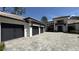 Modern home showcasing a spacious three-car garage with an expansive paver driveway at 16902 Vinci Way, Montverde, FL 34756