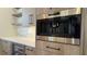 Modern kitchen with a built-in Wolf coffee maker, light wood cabinets, wine cooler, white countertops and open shelving at 16902 Vinci Way, Montverde, FL 34756