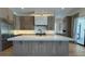 Modern kitchen features a large island, stone backsplash, and stainless steel appliances at 16902 Vinci Way, Montverde, FL 34756