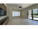 Bright living room with marble floors, large windows, and a modern ceiling fan at 16902 Vinci Way, Montverde, FL 34756