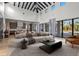 Bright living room boasts black ceiling beams, modern decor, and glass doors to the outdoor pool at 16902 Vinci Way, Montverde, FL 34756