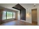 Bright living room with hardwood floors, large window, textured accent wall and modern pendant lighting at 16902 Vinci Way, Montverde, FL 34756