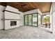 Expansive outdoor living space featuring a cozy fireplace, wood ceiling, and seamless indoor-outdoor transition with sliding glass doors at 16902 Vinci Way, Montverde, FL 34756