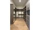Walk-in closet with wood floors, ample shelving, mirrored door, and plenty of storage space at 16902 Vinci Way, Montverde, FL 34756