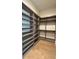 Large walk-in closet featuring custom shelving and wood flooring, providing ample storage and style at 16902 Vinci Way, Montverde, FL 34756