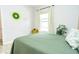 Bright bedroom with a green comforter and large window at 1809 Hawksbill Ln, St Cloud, FL 34771