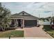 One-story home with green garage door, brick driveway, and well-manicured lawn at 1809 Hawksbill Ln, St Cloud, FL 34771