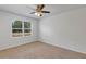 Well-lit bedroom with large window, ceiling fan, and neutral carpeting at 2860 Ne 42Nd Rd, Ocala, FL 34470
