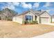 Tan house with gray roof and landscaping at 2860 Ne 42Nd Rd, Ocala, FL 34470