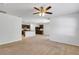 Bright living room with open concept kitchen, neutral carpeting, and ceiling fan at 2860 Ne 42Nd Rd, Ocala, FL 34470