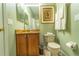A well-maintained bathroom featuring a granite vanity, mirror, toilet, and shower, all in a refreshing green palette at 3632 Calabria Ave, Davenport, FL 33897