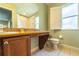 Bright bathroom featuring a wide mirror, tiled floors, and a vanity with granite counter and wood cabinets at 3632 Calabria Ave, Davenport, FL 33897