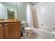 Cozy bathroom featuring a shower-tub combo, tiled floors, and a vanity with warm wood cabinetry at 3632 Calabria Ave, Davenport, FL 33897