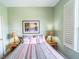 Comfortable bedroom with a large window, shutter blinds, and a bed with decorative pillows at 3632 Calabria Ave, Davenport, FL 33897