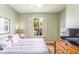 Comfortable bedroom with a large window, shutter blinds, a wooden dresser, and a mounted TV at 3632 Calabria Ave, Davenport, FL 33897