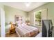 A cozy bedroom featuring natural light, a bed with decorative pillows, and side tables with lamps at 3632 Calabria Ave, Davenport, FL 33897