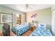 Bright bedroom featuring twin beds, a window with shutters, and a fun, decorative theme at 3632 Calabria Ave, Davenport, FL 33897