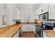 Compact kitchen features white cabinets, granite countertops, and modern appliances at 3632 Calabria Ave, Davenport, FL 33897