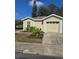 Tan house with a garage and landscaping at 4002 August Ct, Casselberry, FL 32707