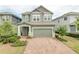 Two-story house with green exterior, brick paver driveway and landscaping at 530 Windy Pine Way, Oviedo, FL 32765